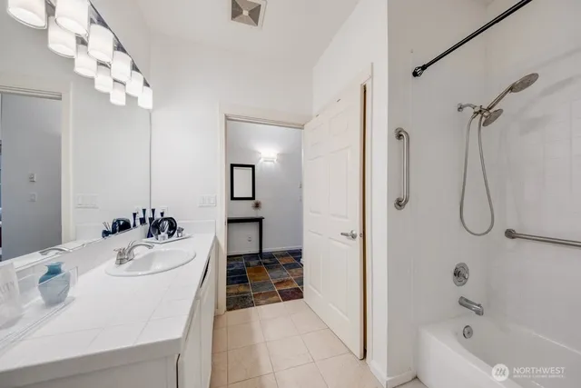 a bathroom with a sink a tub and a mirror