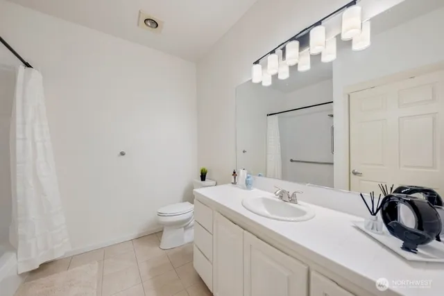 a bathroom with a sink vanity granite and toilet
