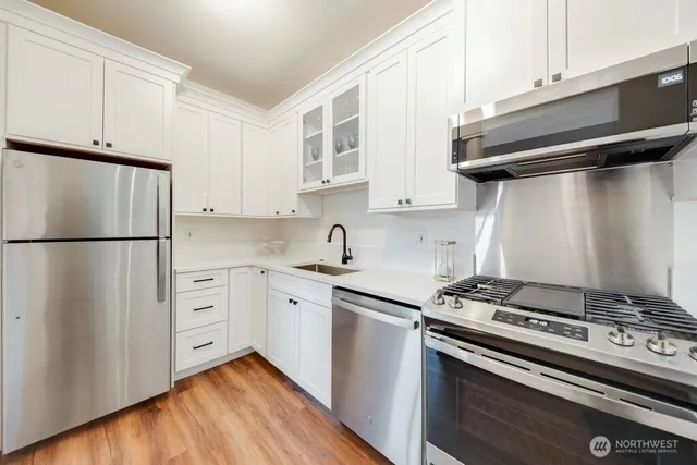 a kitchen with stainless steel appliances a stove a refrigerator and cabinets
