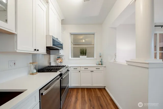 a kitchen with granite countertop white cabinets and white appliances