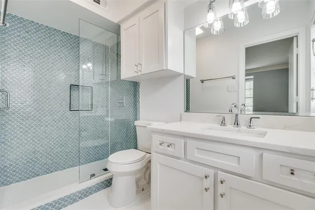 a bathroom with a sink a toilet and shower