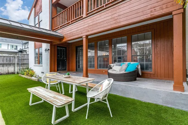 a patio with a table and chairs and potted plants
