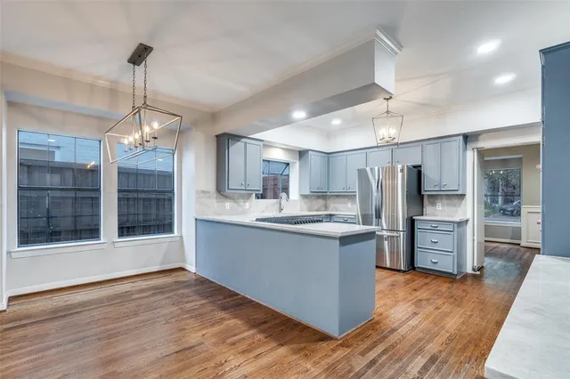 a kitchen with stainless steel appliances kitchen island granite countertop a refrigerator and a stove top oven