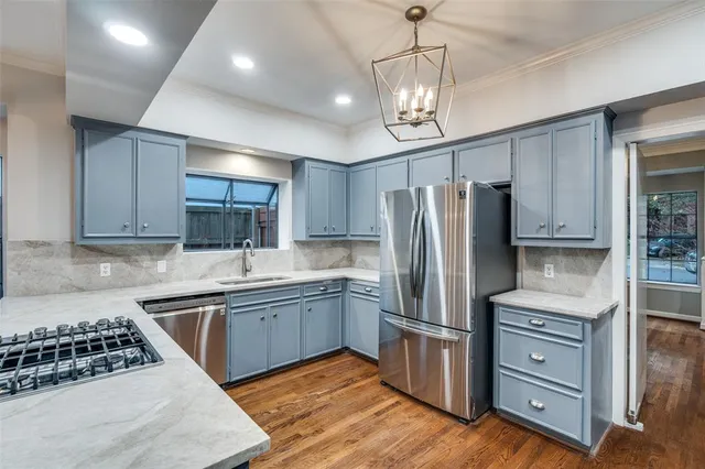 a kitchen with stainless steel appliances granite countertop a sink stove and refrigerator
