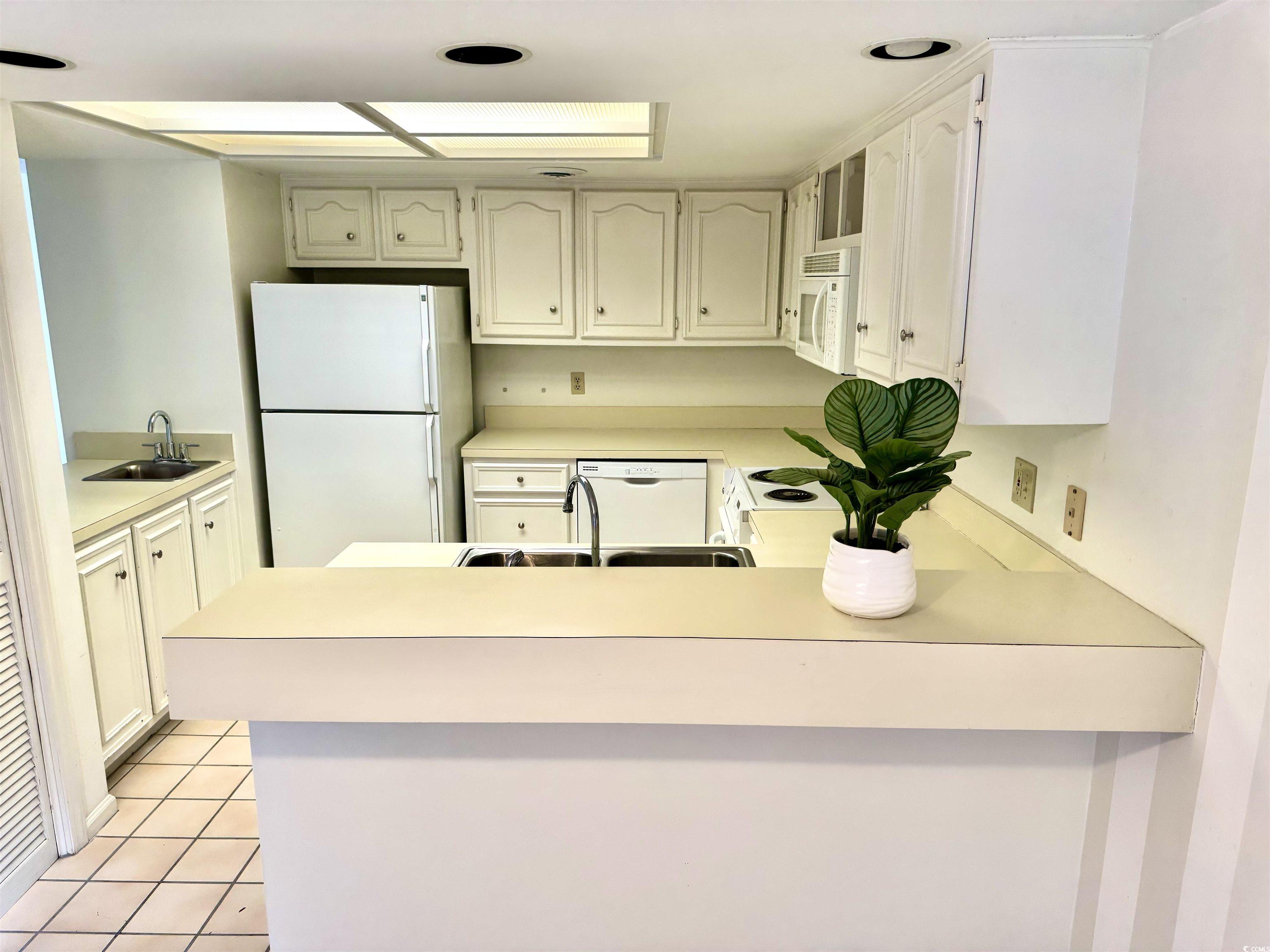 31 Battery White Court, Unit 1005 Georgetown, SC 29440 - Photo 11 of 34 Kitchen featuring light countertops, white appliances, and white cabinetry