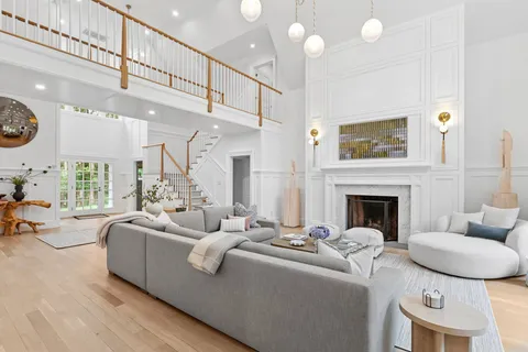 a living room with furniture a fireplace and a large window