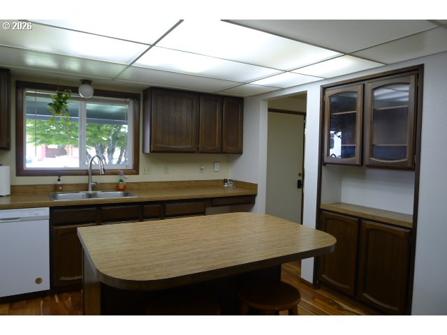412 Camellia Court Reedsport, OR 97467 - Photo 24 of 48 a kitchen with a table chairs and wooden cabinets