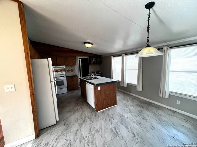 a kitchen with refrigerator and wooden floor