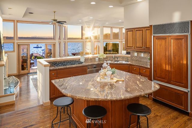 a view of a kitchen with stainless steel appliances granite countertop a stove and a refrigerator