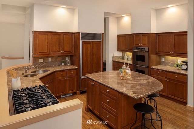 a kitchen with a stove a refrigerator and a wooden cabinets
