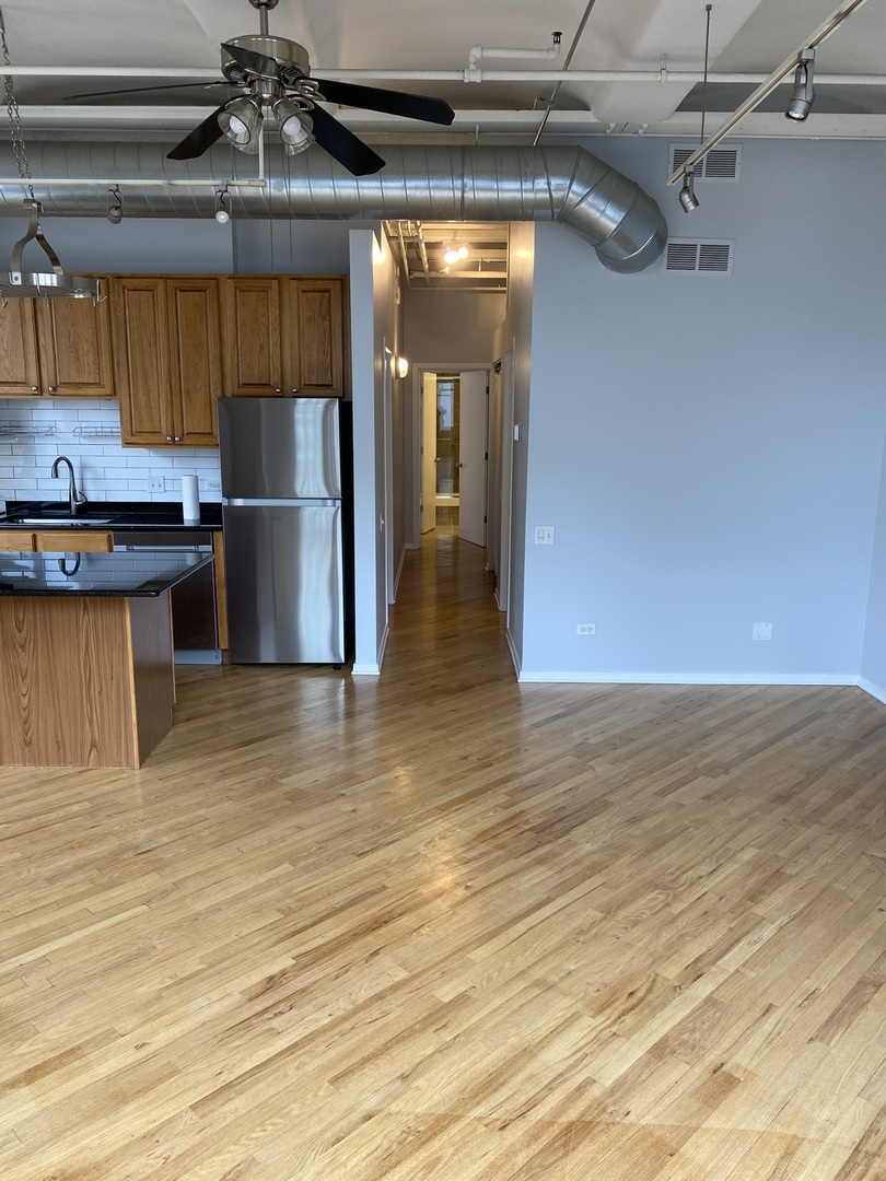 500 South Clinton Street, Unit 404 Chicago, IL 60607 - Photo 15 of 46 a view of a kitchen with stainless steel appliances wooden floor and chair