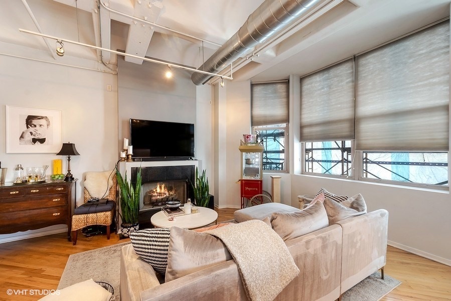 500 South Clinton Street, Unit 404 Chicago, IL 60607 - Photo 10 of 46 a living room with furniture a flat screen tv and a fireplace