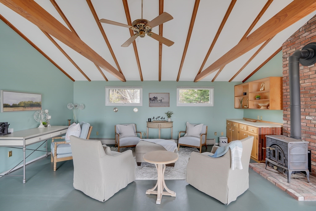 453 Lighthouse Road Aquinnah, MA 02535 - Photo 12 of 39 a living room with furniture a flat screen tv and a floor to ceiling window