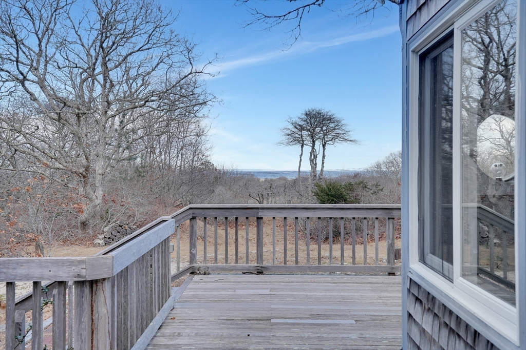 453 Lighthouse Road Aquinnah, MA 02535 - Photo 30 of 39 a balcony with wooden floor and bench