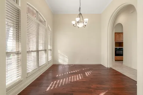 a view of a livingroom with wooden floor and windows