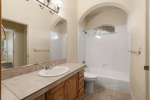 a bathroom with a granite countertop sink a toilet and shower
