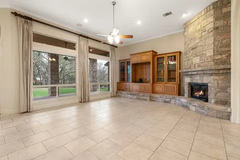 a view of an empty room with a fireplace and a window