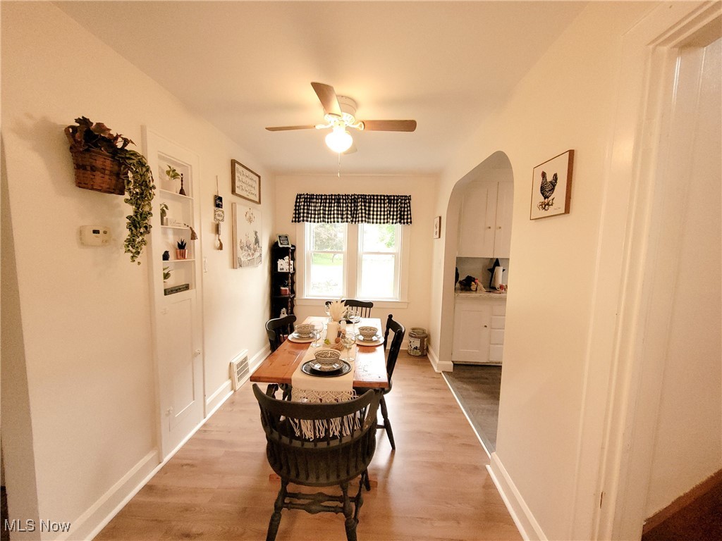 3524 State Road Ashtabula, OH 44004 - Photo 13 of 45 Dining room featuring light wood-style flooring, a ceiling fan, arched walkways, and baseboards