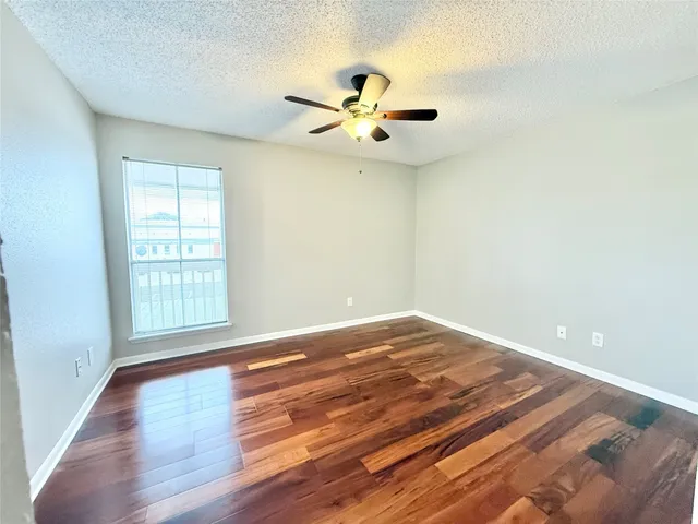a view of a kitchen with wooden floor and a ceiling fan