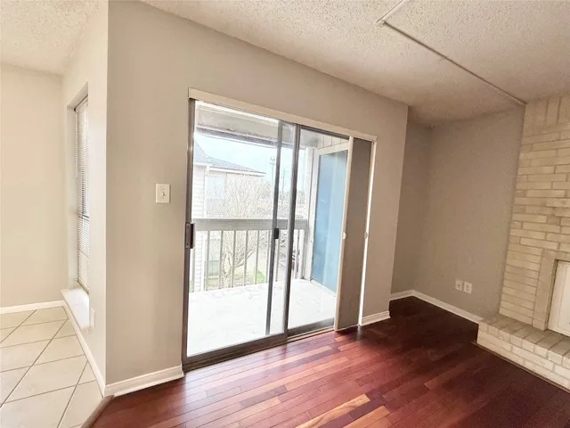 an empty room with wooden floor and door