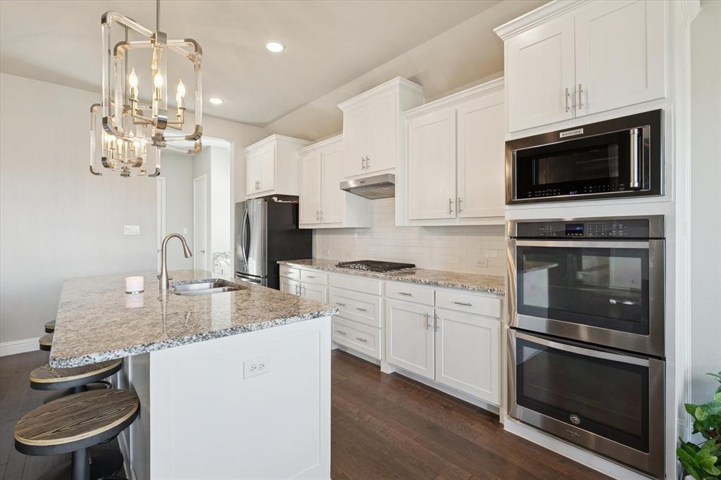 11375 Misty Ridge Drive Flower Mound, TX 76262 - Photo 10 of 36 a kitchen with stainless steel appliances granite countertop a stove microwave and sink