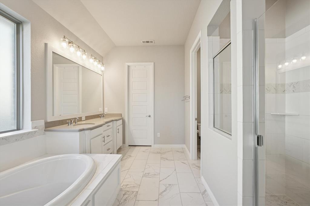 11375 Misty Ridge Drive Flower Mound, TX 76262 - Photo 17 of 36 a spacious bathroom with a granite countertop tub sink and mirror