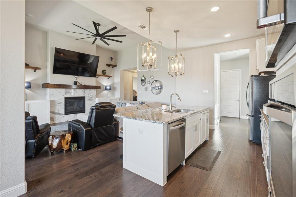 11375 Misty Ridge Drive Flower Mound, TX 76262 - Photo 35 of 36 a large kitchen with stainless steel appliances kitchen island granite countertop a stove and a view of living room