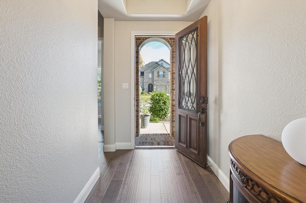 11375 Misty Ridge Drive Flower Mound, TX 76262 - Photo 5 of 39 a view of a hallway to a livingroom with wooden floor and furniture