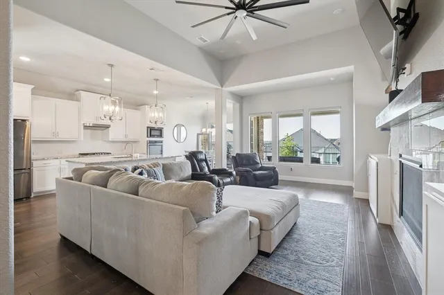 a large kitchen with stainless steel appliances kitchen island granite countertop a stove and a view of living room