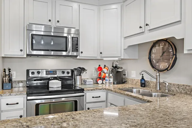 a kitchen with stainless steel appliances granite countertop a stove and cabinets