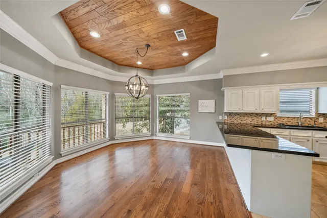 a view of a kitchen with wooden floor and stainless steel appliances