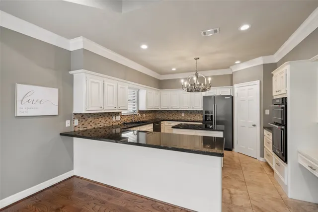 a kitchen with stainless steel appliances granite countertop a sink and a refrigerator