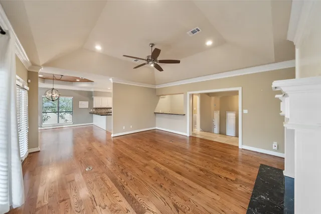 a view of empty room with wooden floor and a ceiling fan