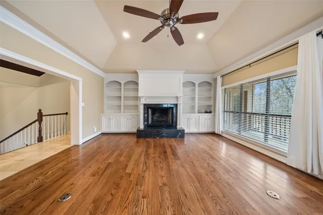 a view of empty room with wooden floor and fireplace