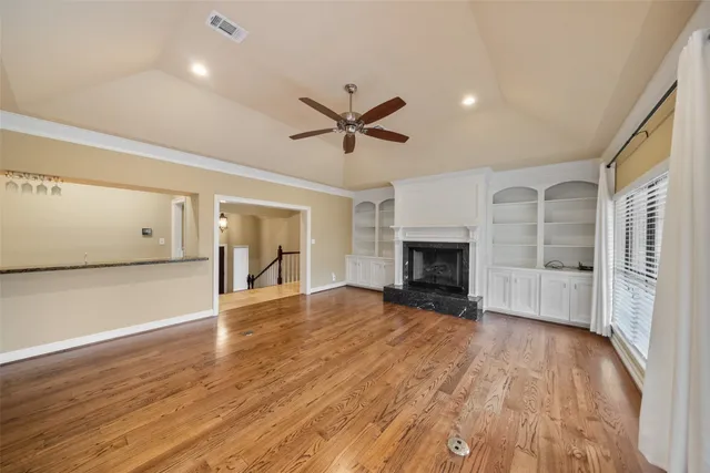 an empty room with wooden floor and a fireplace