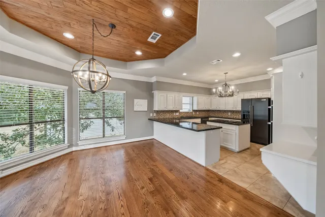 a large kitchen with kitchen island a large counter space a sink appliances and cabinets