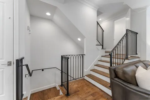 a view of a hallway with wooden floor and staircase