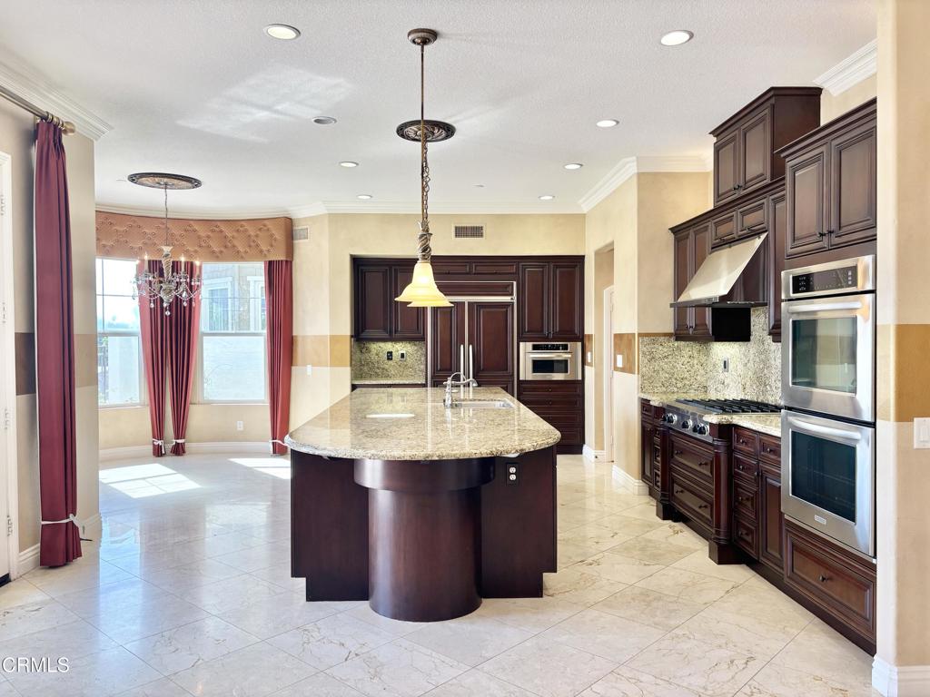 1702 Aleutian Way Oxnard, CA 93035 - Photo 26 of 73 a large kitchen with stainless steel appliances kitchen island granite countertop a sink and cabinets