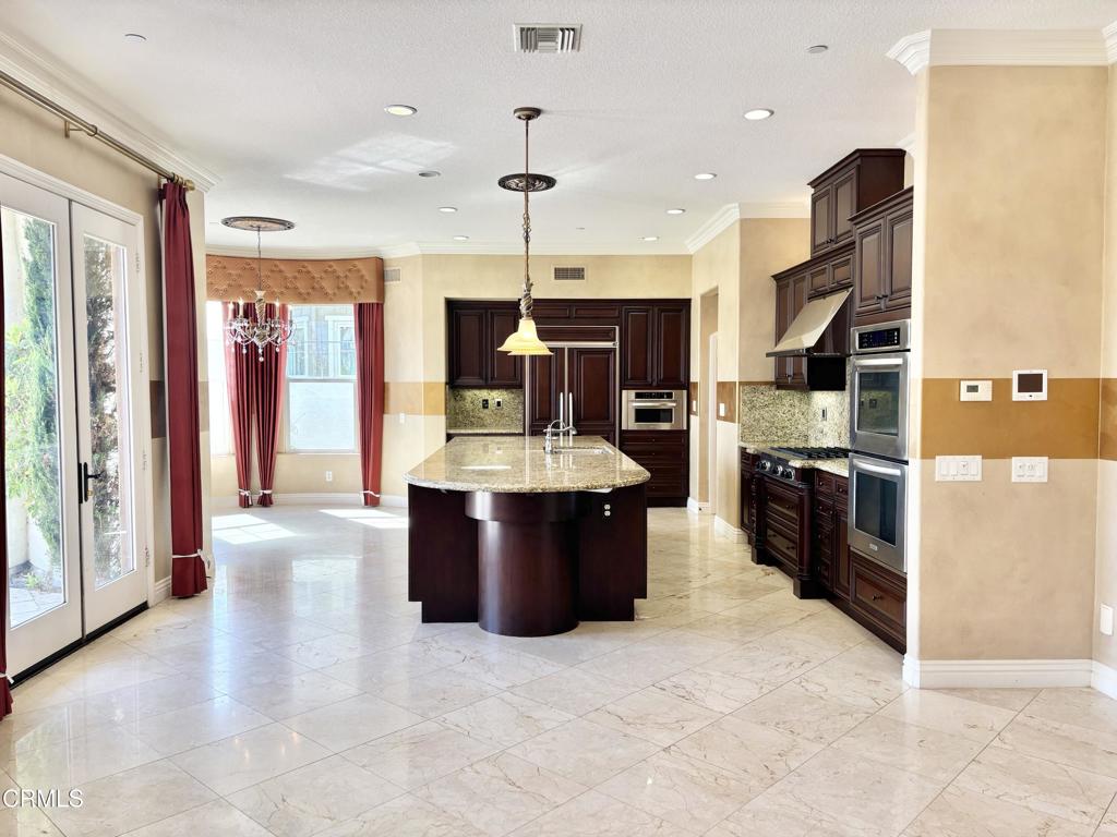 1702 Aleutian Way Oxnard, CA 93035 - Photo 28 of 73 a large kitchen with stainless steel appliances kitchen island granite countertop a stove and a refrigerator