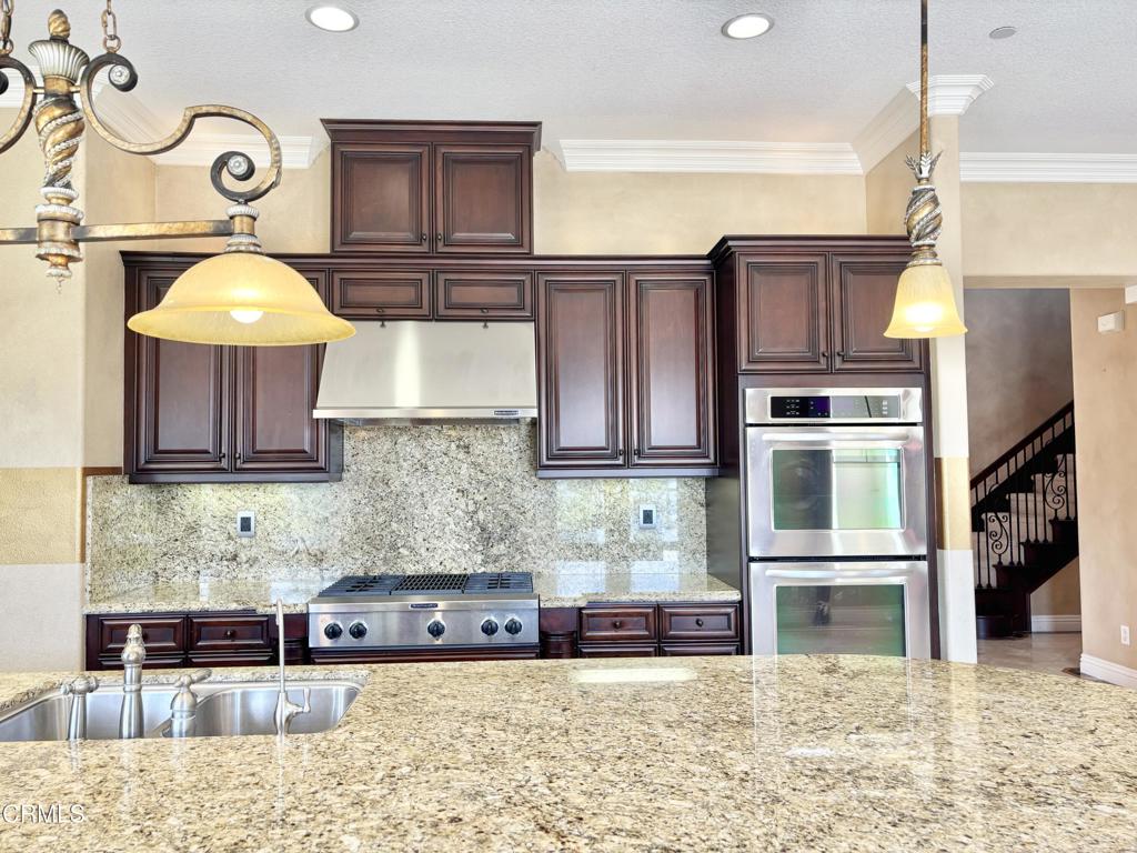 1702 Aleutian Way Oxnard, CA 93035 - Photo 30 of 73 a kitchen with stainless steel appliances granite countertop a refrigerator a stove and a cabinets with wooden floor