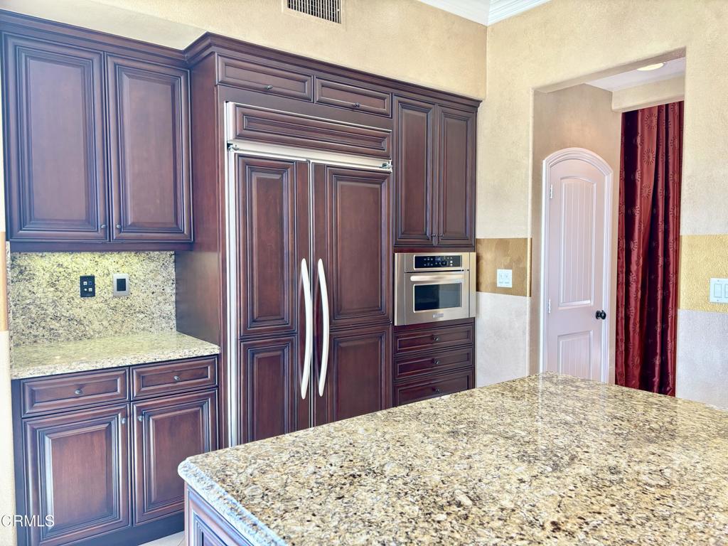 1702 Aleutian Way Oxnard, CA 93035 - Photo 31 of 73 a kitchen with stainless steel appliances granite countertop a refrigerator and wooden cabinets