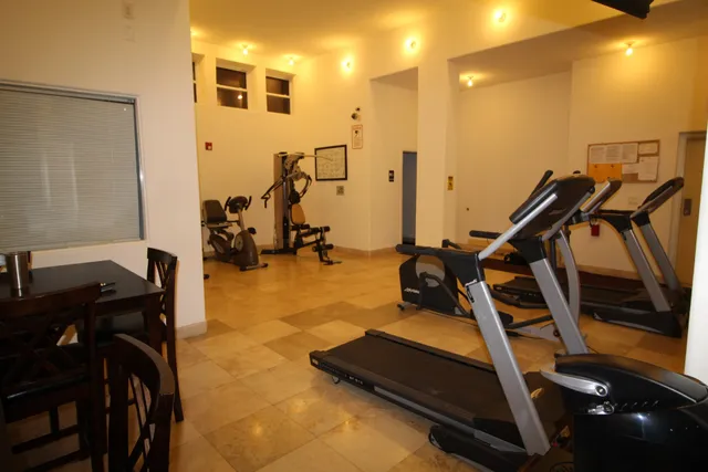 a room with gym equipment and large mirror