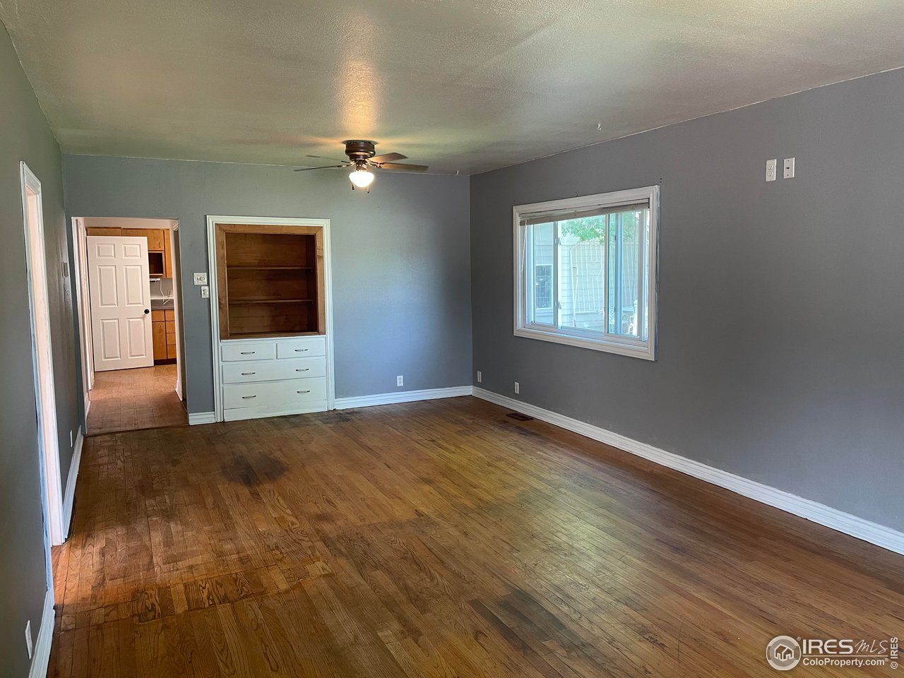 21 Main Street Windsor, CO 80550 - Photo 4 of 12 an empty room with wooden floor ceiling fan and windows