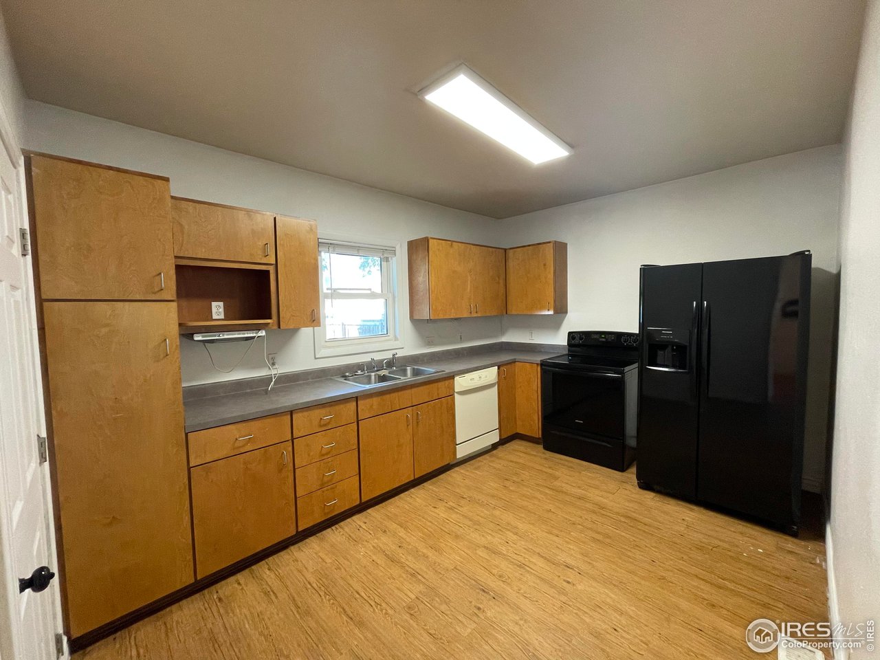21 Main Street Windsor, CO 80550 - Photo 5 of 12 a kitchen with granite countertop a refrigerator and a sink