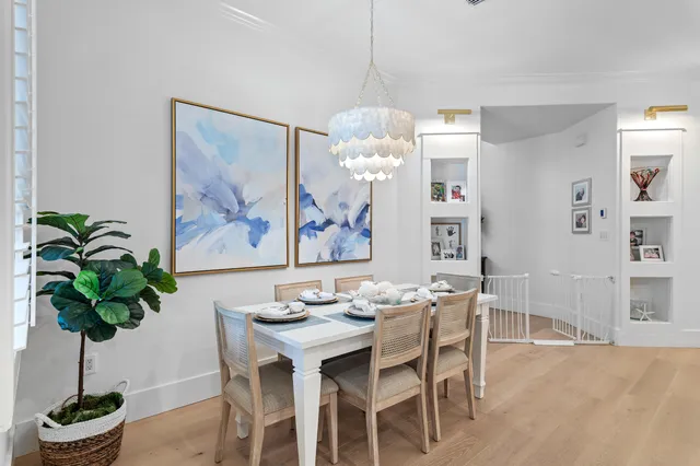 a dining room with furniture potted plants and a chandelier
