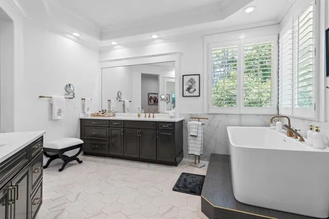 a en suite bathroom with a double vanity sink a mirror and a bathtub