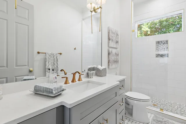 a bathroom with a granite countertop sink toilet and shower