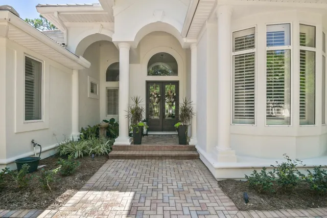 a view of a brick house with potted plants