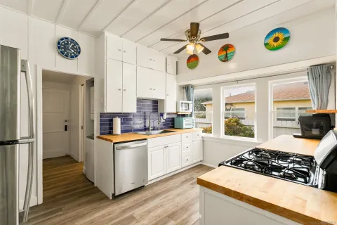 a kitchen with a refrigerator a stove and wooden floor