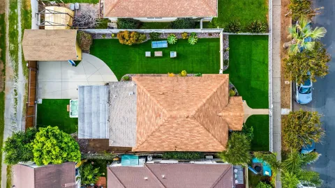 an aerial view of a house with garden space and street view